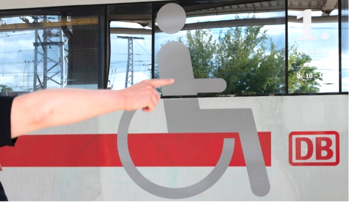 DB Wagen mit Rollstuhlsymbol und Arm und Finger die darauf zeigen